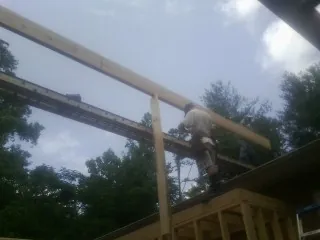 Carpenter setting a ridge beam over a new addition frame — Ice Dam Removal by Roofing Brothers in Hatfield