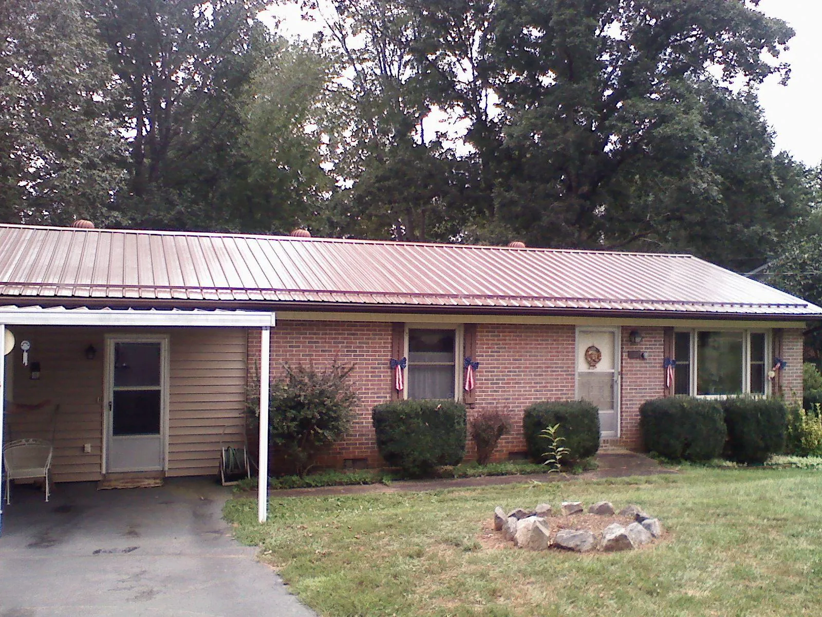 Bronze metal roof and carport on a brick ranch home — Roof Repair work by our crew in Hatfield